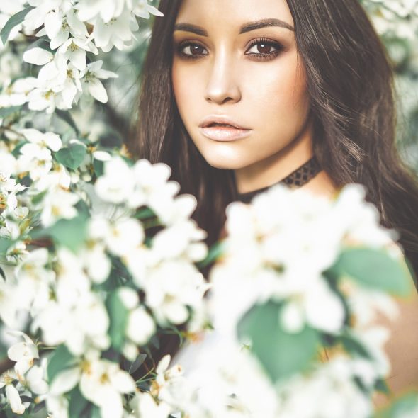 Beautiful young woman surrounded by flowers of apple-tree Outdoor fashion photo of beautiful young woman surrounded by flowers of apple-tree. Spring blossom. Summer vibes